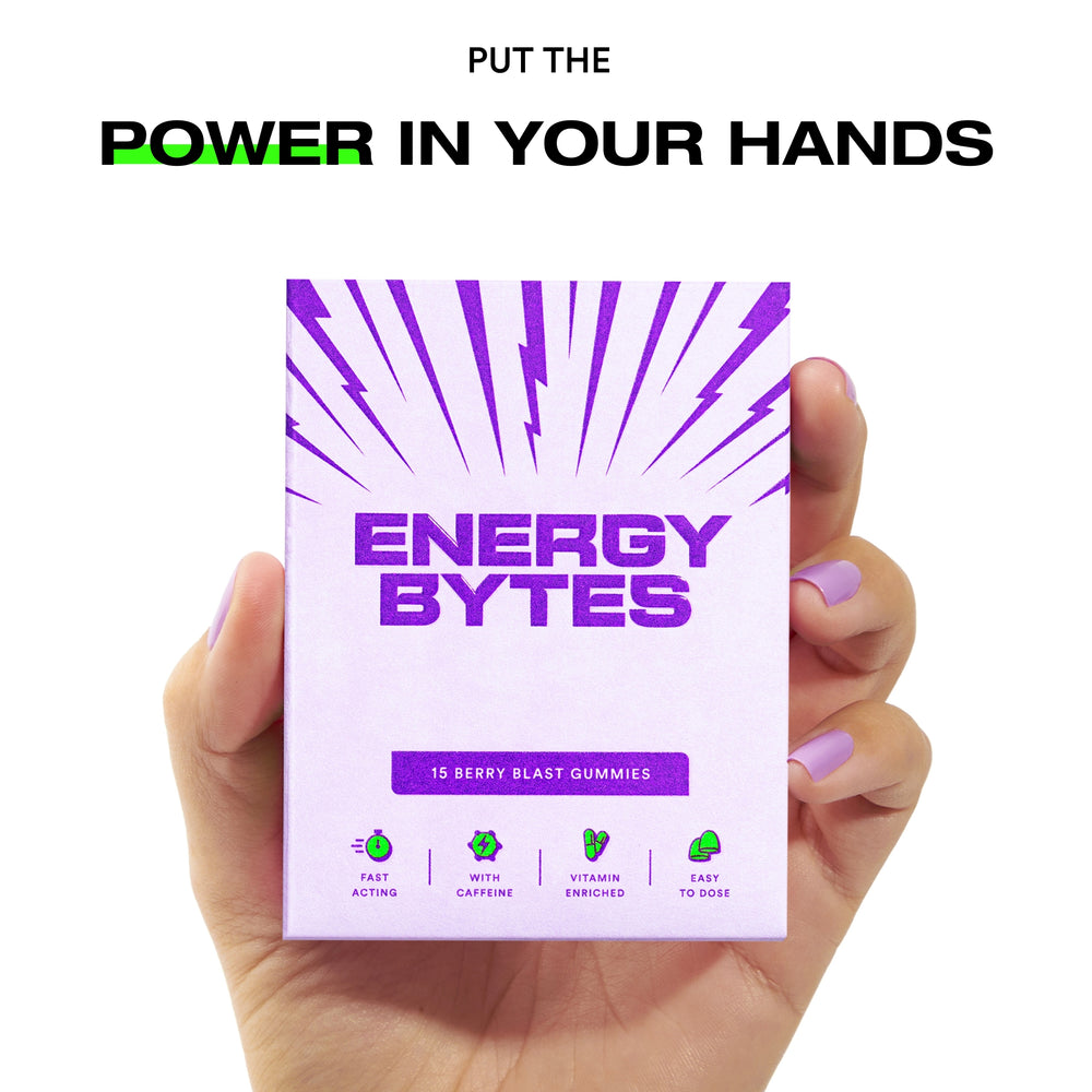 Hand with purple nails holding a pack of Energy Bytes Berry Blast Gummies with text above reading 'PUT THE POWER IN YOUR HANDS'.