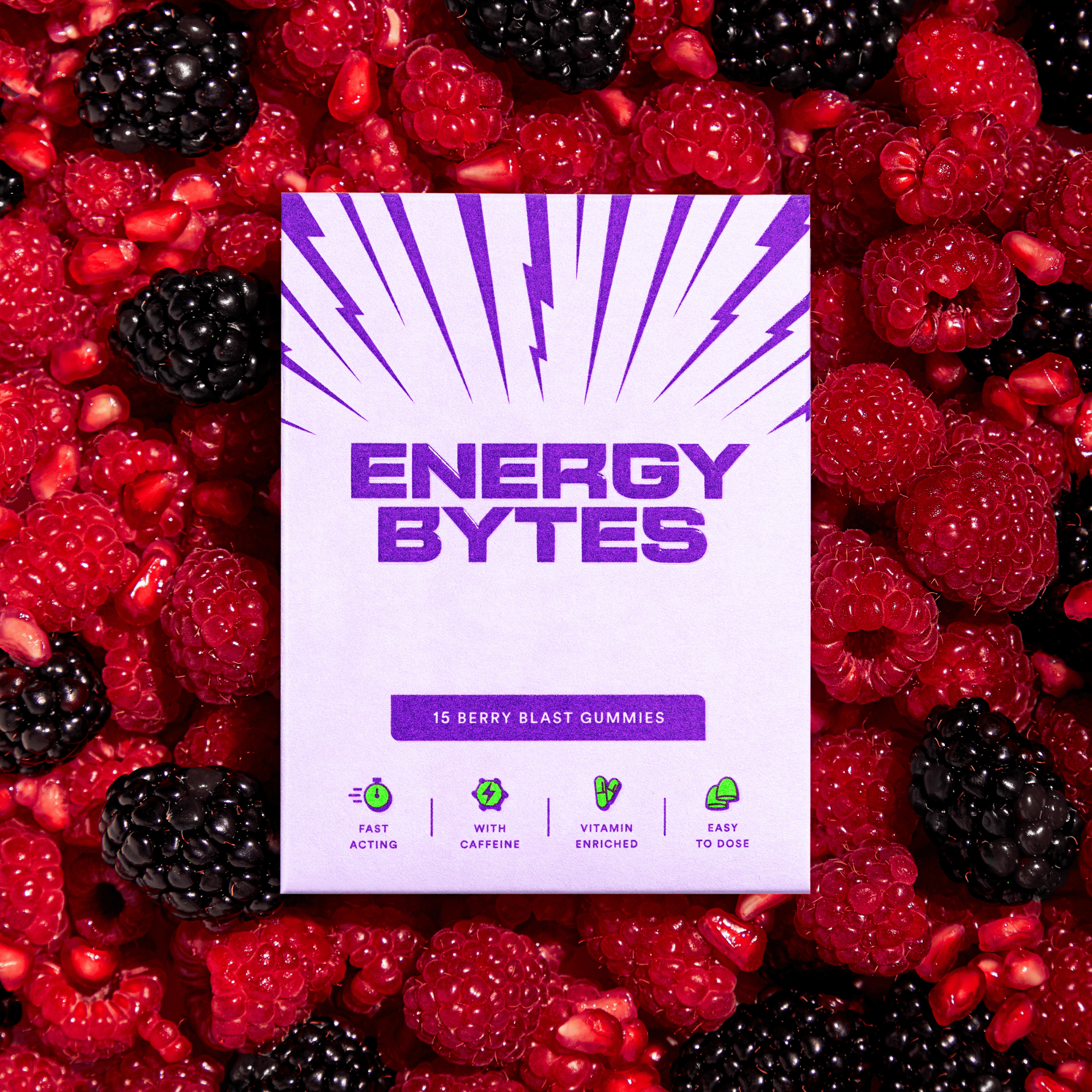 Energy Bytes Berry Blast Gummies package with purple accents, nestled in a mix of ripe blackberries and raspberries, featuring the natural berry essence and vitality enhancement.