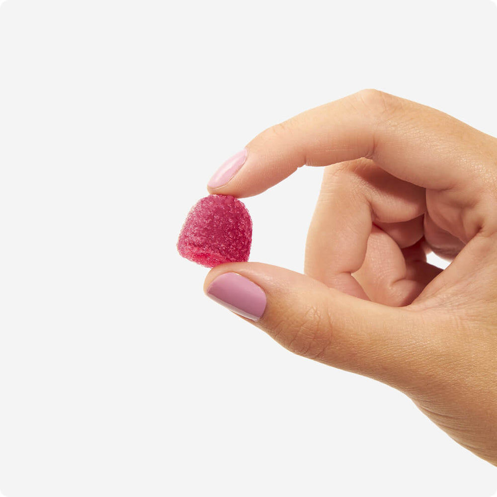 Hand holding one Wild Strawberry Flavour Energy Byte, our caffeine-powered gummy. Experience the boost of natural energy from Energy Bytes in a convenient and delicious package.